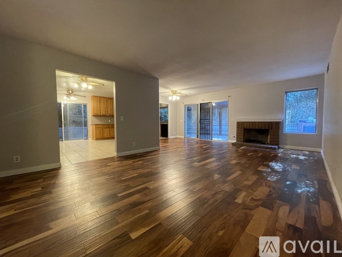 A spacious living room with hardwood floors and a fireplace.
