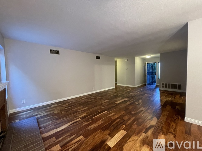 A room with wooden flooring and a ceiling fan.