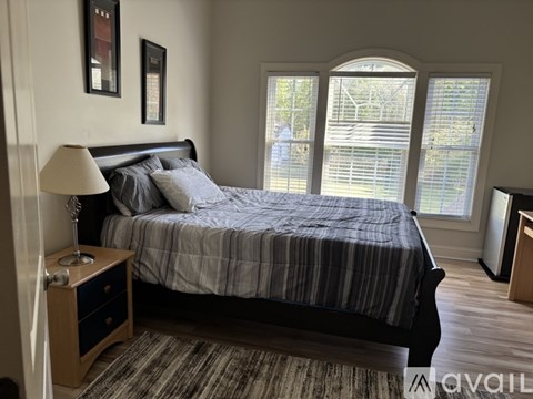 A white desk with a beige chair and a blue and white painting on the wall.