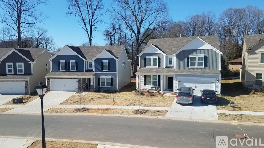 A row of houses with a car parked in front of the first one.