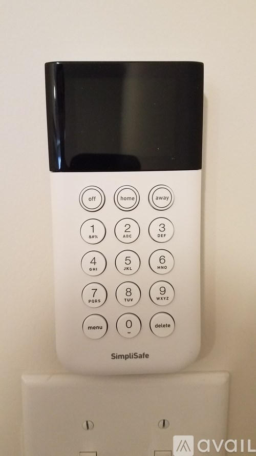 A white SimiSafe device with a black screen and a keypad with numbers and buttons.