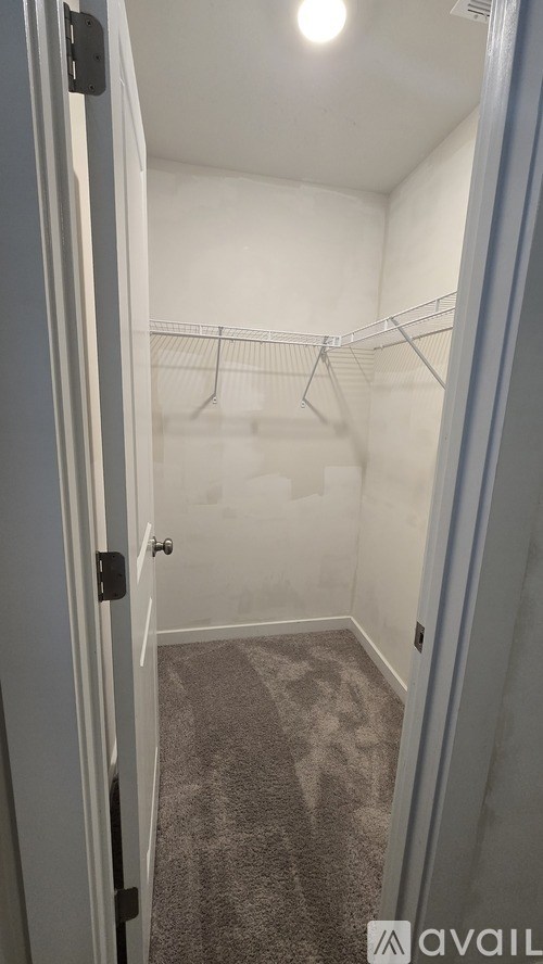 A small, empty closet with a carpeted floor and a single hanger.