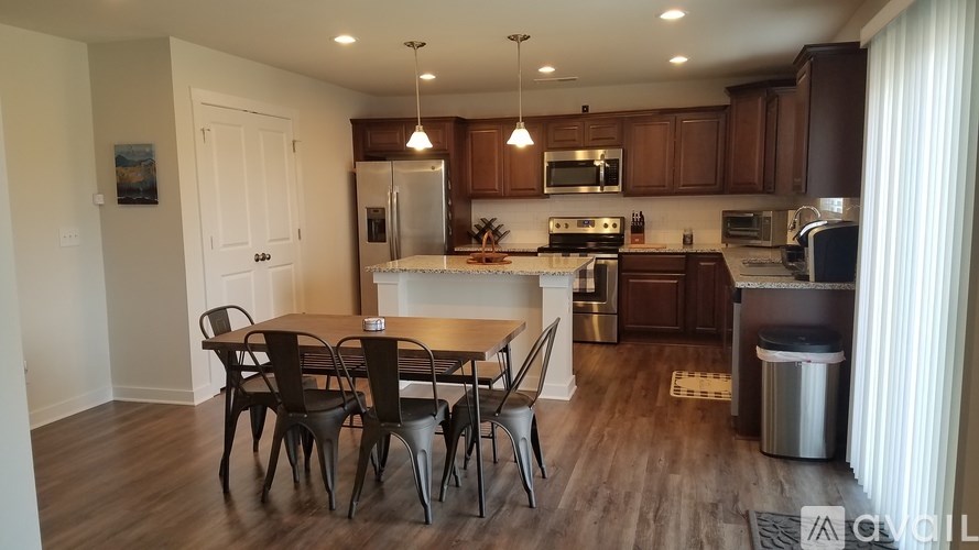 A kitchen with a dining table and chairs.