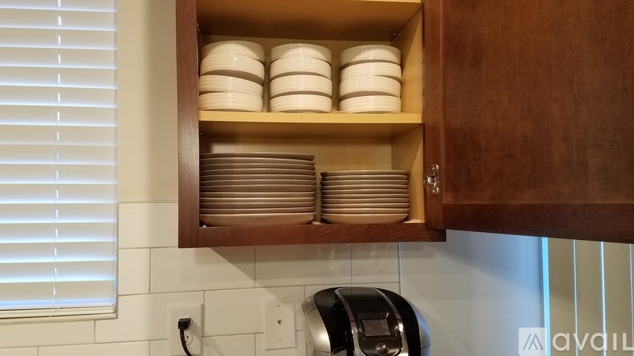 A kitchen cabinet with plates stacked inside.