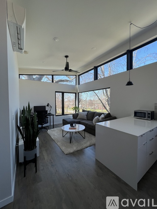 A modern kitchen with a large island and a dining area with a couch and chairs.