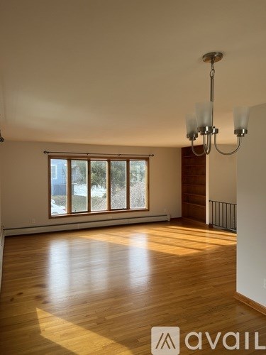 A room with wooden floors and a chandelier.