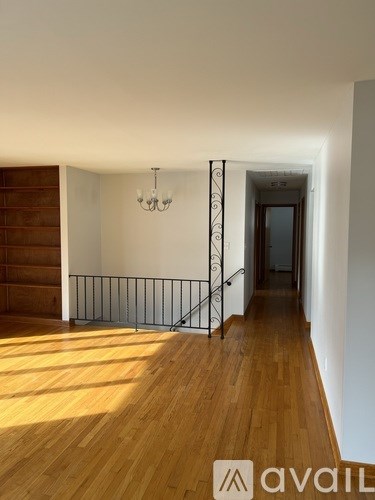 A room with wooden floors and a chandelier.
