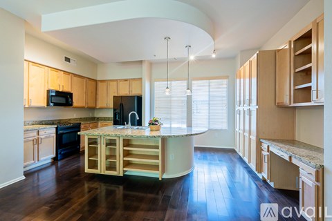 A kitchen with wooden cabinets and a black refrigerator.