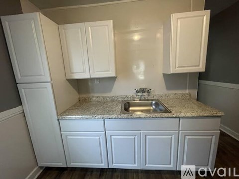 A kitchen with white cabinets and a granite countertop.