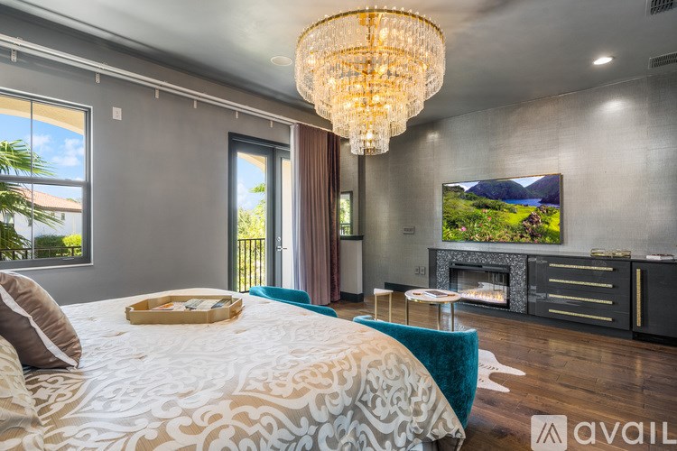 A bedroom with a large bed and a chandelier.
