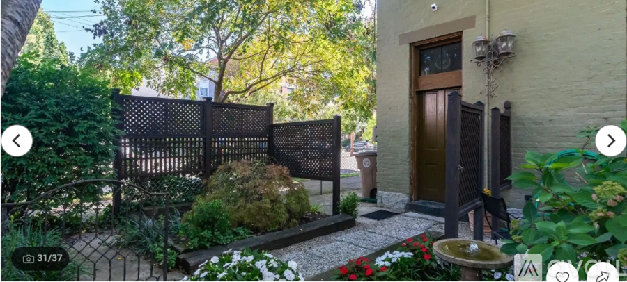 A garden with a fence, a door, and a wall.
