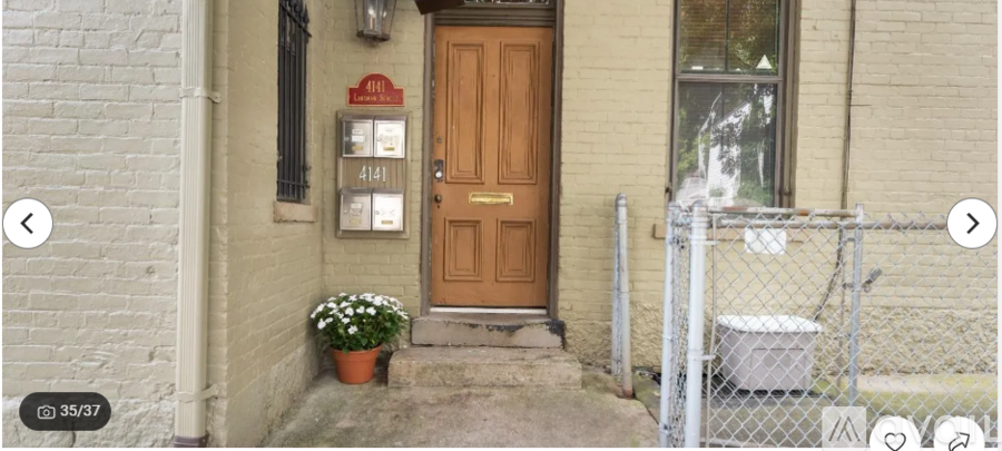 A brown door with a mailbox on the left and a flower pot on the right.