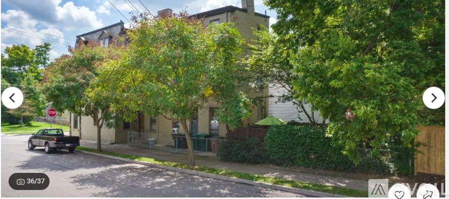 A street view of a residential area with houses and trees.