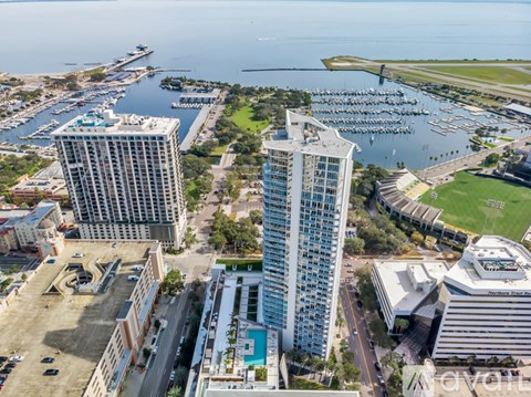 A cityscape with two tall buildings in the foreground and a marina in the background.