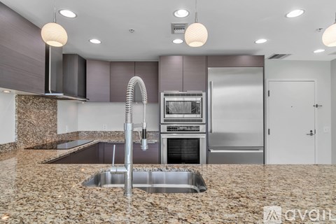 A modern kitchen with granite countertops and stainless steel appliances.