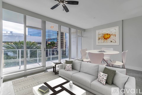 A living room with a grey couch, a white coffee table, and a ceiling fan.
