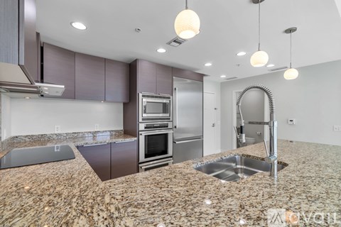 A modern kitchen with granite countertops and stainless steel appliances.