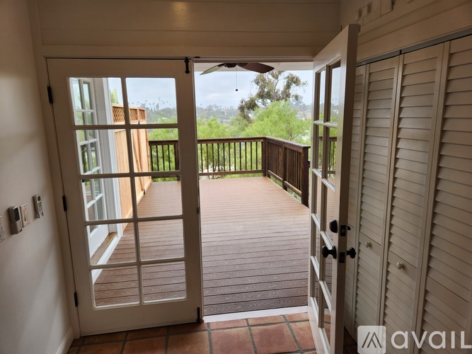 A balcony with a door leading to a patio.