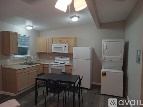 A kitchen with a table and chairs in the middle of it.