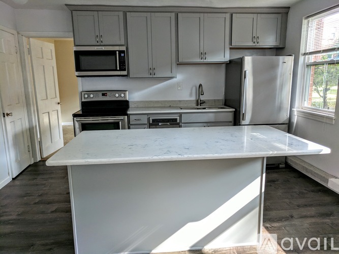 A kitchen with a white island in the middle.