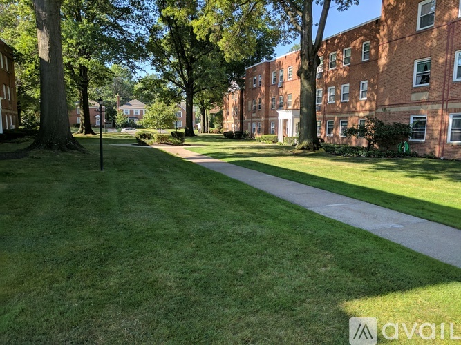 A grassy area with a pathway in front of a brick building.