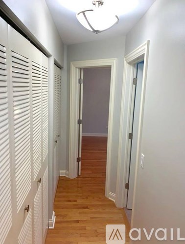 A hallway with white walls and wooden floors.