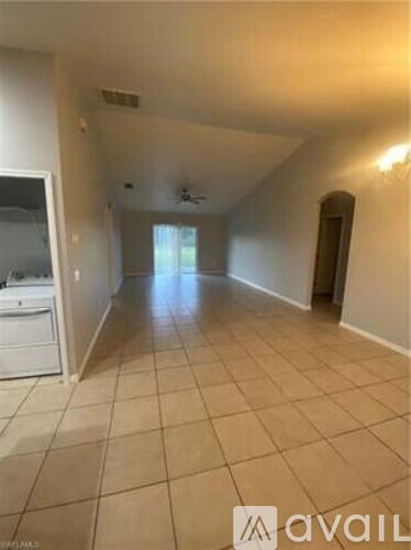 A spacious room with tiled flooring and a ceiling fan.