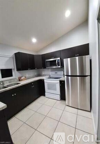 A kitchen with black cabinets and stainless steel appliances.