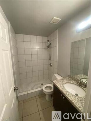 A bathroom with a toilet, sink, and shower.