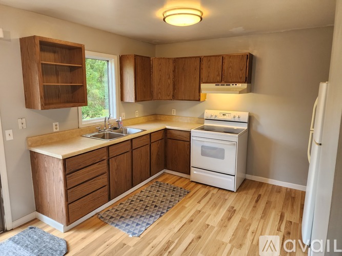 A kitchen with wooden cabinets and a white stove top oven.
