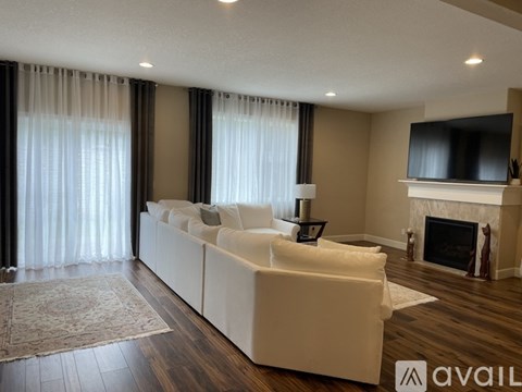 A living room with a white couch and a fireplace.