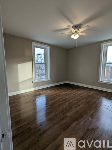 A room with wooden floors and a ceiling fan.
