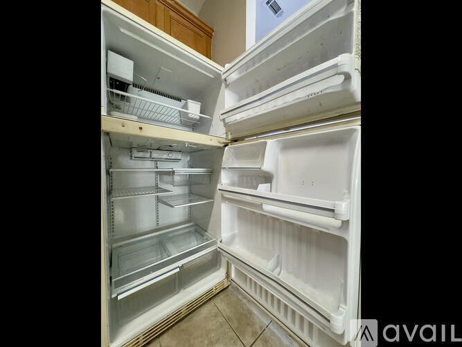 A white refrigerator with the door open and shelves inside.
