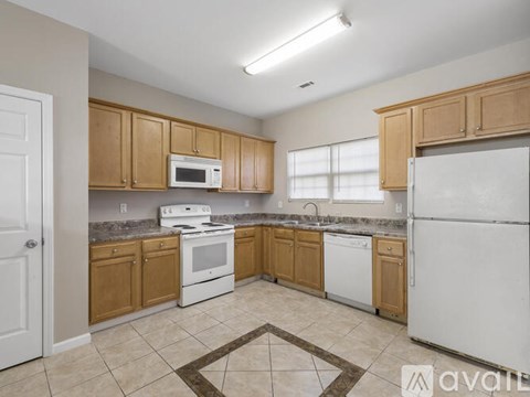 A kitchen with wooden cabinets and white appliances.