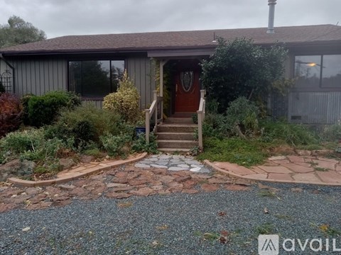 A house with a brown door and a stone pathway leading to it.