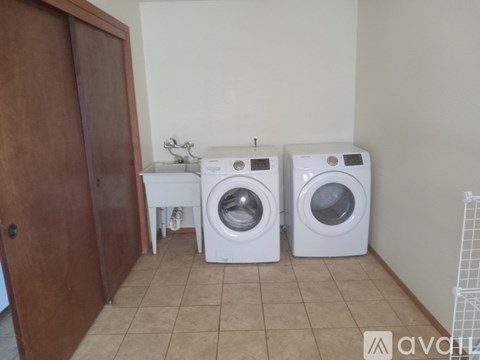 A room with two washing machines and a wooden door.