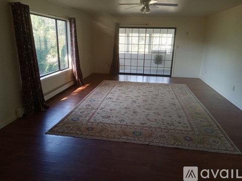 A room with a rug on the floor and a ceiling fan.