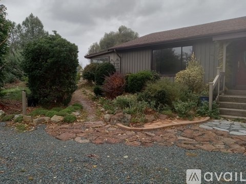 A house with a gravel driveway and a stone pathway leading to the front door.
