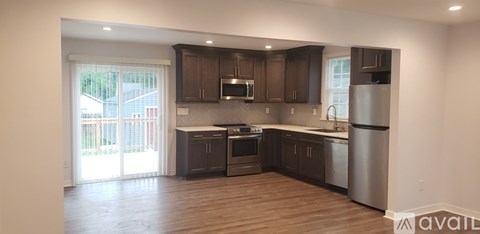 A kitchen with dark wood cabinets and stainless steel appliances.