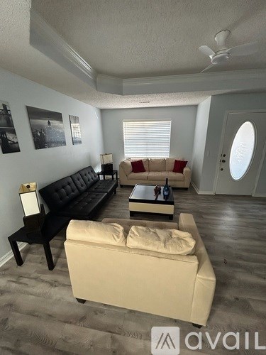 A living room with a black couch and a beige sofa.