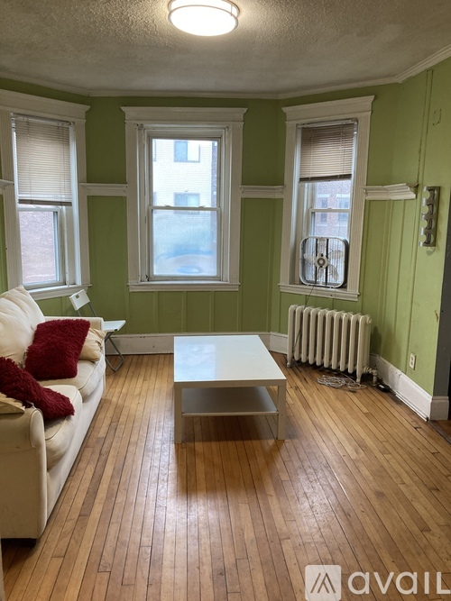A living room with a white couch and a wooden floor.