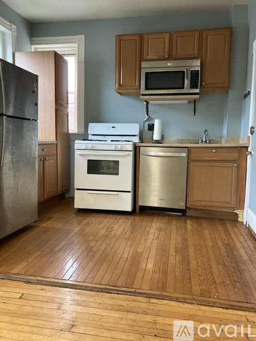 A kitchen with wooden floors and a white stove top oven.