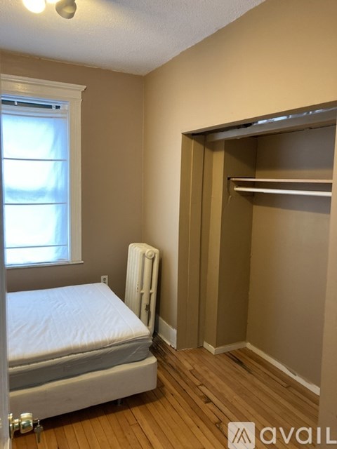 A bedroom with a bed, a window, and a closet.