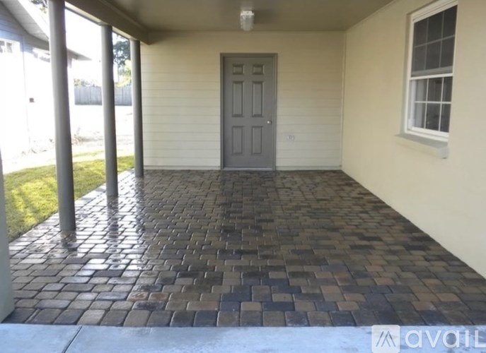 A patio with a grey door and a brick pattern floor.