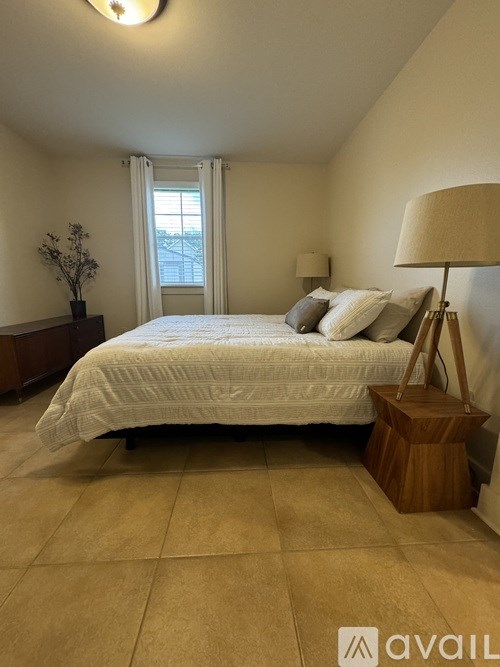 A bedroom with a bed, nightstand, and lamp.