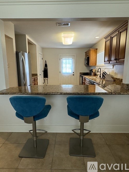 Two blue bar stools in front of a kitchen island.