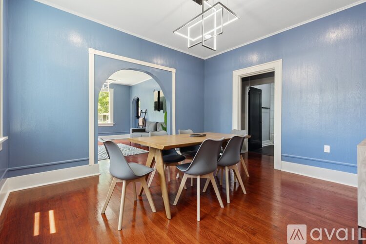 A dining room with a wooden table and chairs.