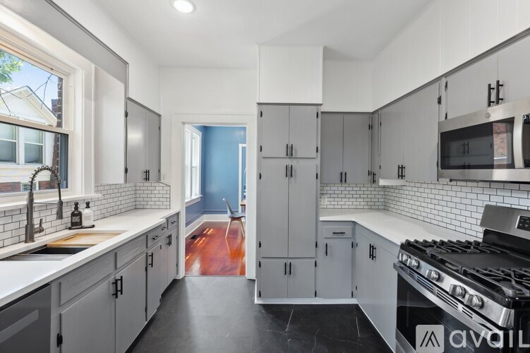 A kitchen with white cabinets and a black stove top.