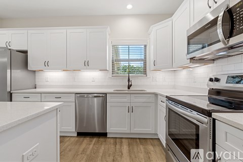A kitchen with white cabinets and stainless steel appliances.