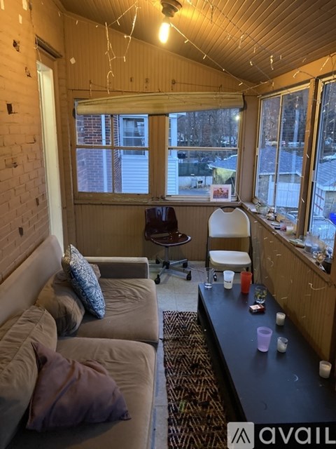 A living room with a couch, a chair, and a table with candles on it.